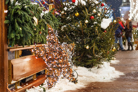 圣诞和新年背景与冷杉树和明亮的装饰星-户外装饰由柳树枝制成，带有灯泡花环。