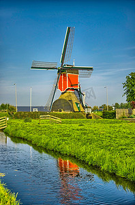 荷兰语摄影照片_小孩堤防、荷兰或荷兰的风车和水运河。