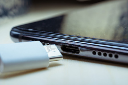 智能手机上的白色 USB C 型电缆和 USB-C 端口