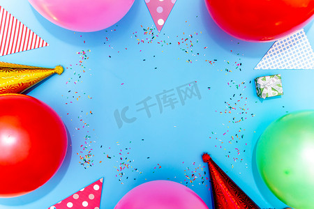 蓝色桌面视图上的彩色气球和五彩纸屑。
