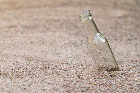 沙子上的空玻璃瓶 垃圾污染的概念