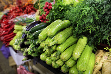 榨萝卜汁摄影照片_西葫芦、莳萝、欧芹和茄子、萝卜的多汁蔬菜在市场上出售