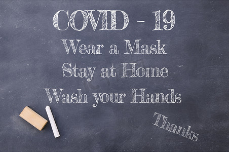 上洗手摄影照片_Covid-19 戴面具，呆在家里，洗手，在黑板上题词。