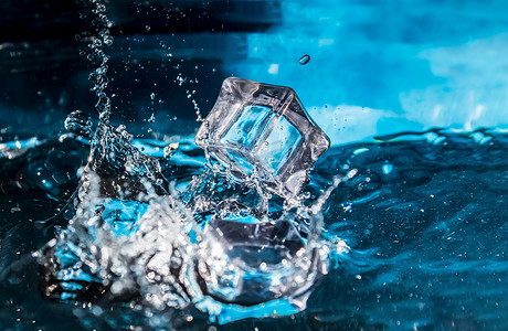落入水中摄影照片_落入蓝色水中的冰块。