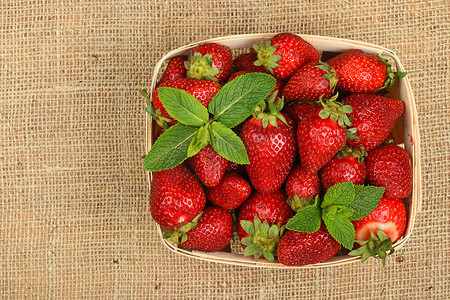 画布篮子里的草莓和薄荷叶