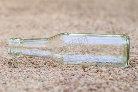 海洋塑料垃圾污染摄影照片_沙子上的空玻璃瓶 垃圾污染的概念