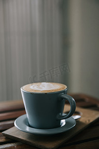 木桌上用牛奶制成的卡布奇诺或拿铁艺术咖啡