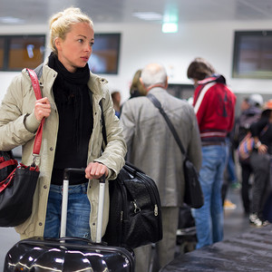女性旅客在机场运送行李。