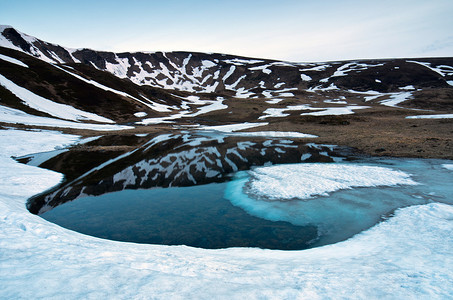 透明蓝色底摄影照片_湖水透明、冰底远方的景观