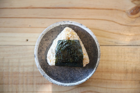 在木头背景的 Onigiri 地方日本食物