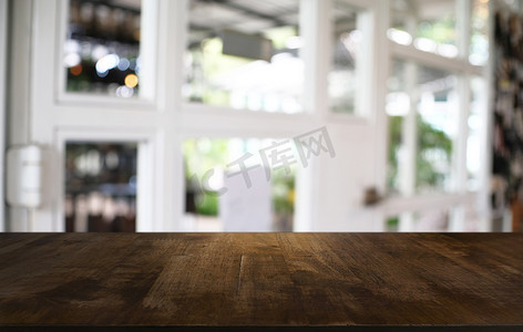 深色桌面摄影照片_抽象模糊散景黑色前的空深色木桌
