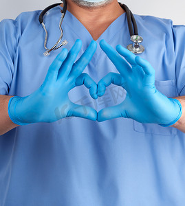 蓝色制服和乳汁手套的医生显示心脏姿态