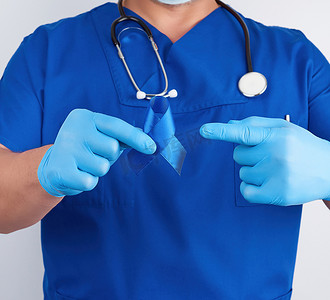 穿着蓝色制服和无菌乳胶手套的医生拿着深蓝色