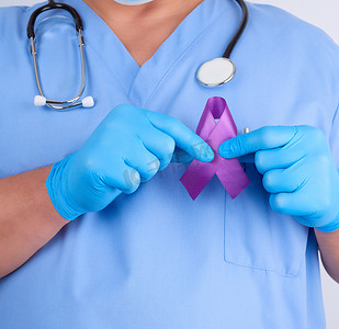 蓝色制服和乳汁手套的医生拿着一条紫色丝带
