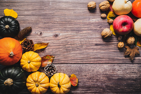 南瓜坚果摄影照片_木桌上有南瓜和坚果的感恩节快乐