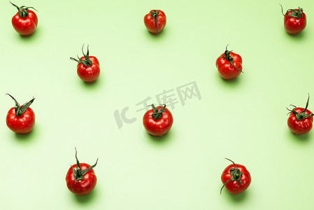 几何绿色背景摄影照片_绿色背景上的红番茄几何图案。