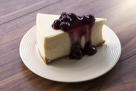 木桌白盘蓝莓奶油芝士蛋糕