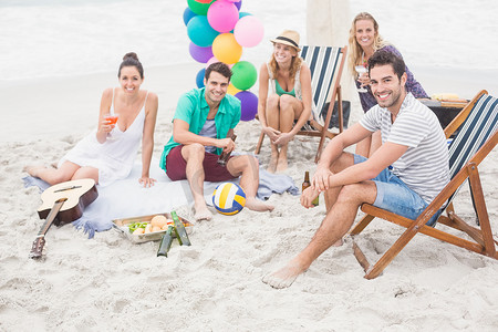 一群朋友在沙滩上一起喝酒玩乐