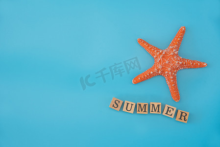 顶视图模拟海星和单词“SUMMER”放在蓝色 b 上