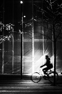 人物剪影创意摄影照片_运动蓝光中骑自行车的人轮廓的高对比度图像