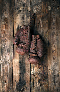 击拳摄影照片_非常旧的皮革棕色拳击手套挂