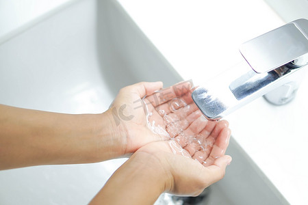 水里细菌摄影照片_特写女人的手拿着水在浴室里清洗，sel