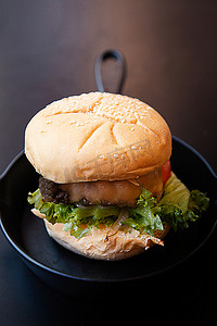 好吃的汉堡包摄影照片_食物含量的铁锅图像上的汉堡包。