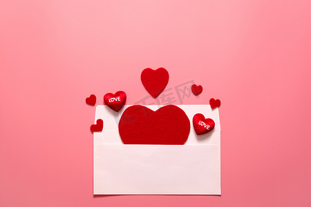 情人节概念，粉红色背景上的红心白色信封