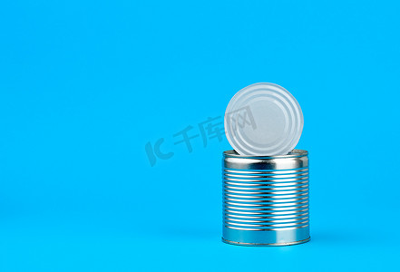 铁罐可口可乐摄影照片_打开蓝色背景中食品保鲜用的硬铁罐