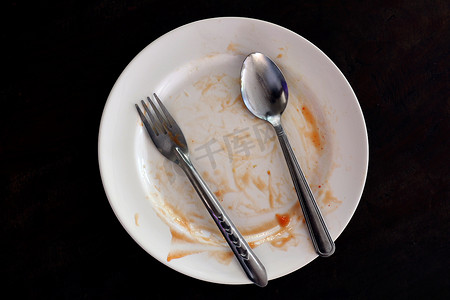 吃完食物、盘叉和勺子后的空盘子和脏盘子
