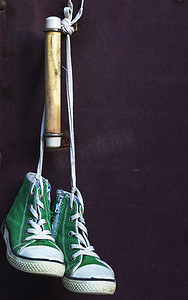 绿色经典摄影照片_白色蕾丝上挂着非常古老的绿色经典运动鞋