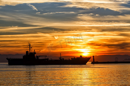 海上太阳摄影照片_海上日落时的散货船