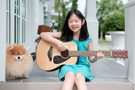 手绘61儿童节摄影照片_亚洲儿童与狗一起弹吉他