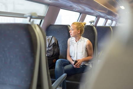 手机旅行摄影照片_乘火车旅行的女人。