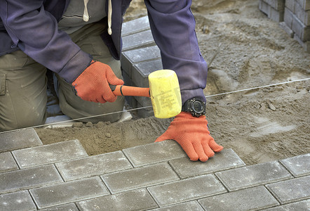 在人行道上铺瓷砖，工人铺瓷砖，将其对准螺纹
