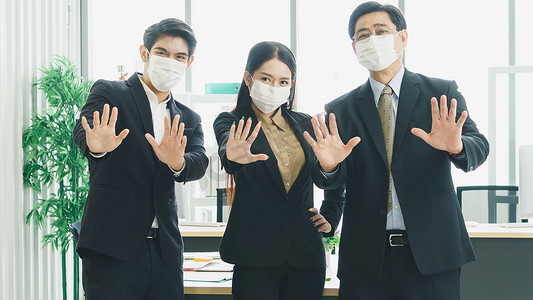 疫情范围摄影照片_一个戴着工作面具的商业团队