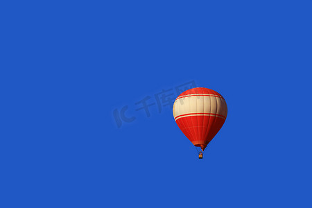 一个红色的气球漂浮在老挝万荣的蓝天背景上