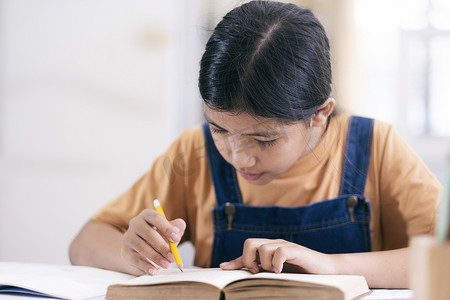 女孩在家摄影照片_亚洲女孩在家读书和做作业
