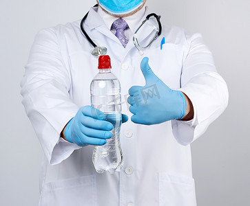 一件白色外套和蓝色乳汁手套的医生拿着透明
