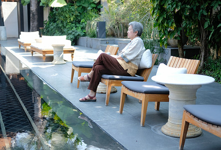老妇人在酒店游泳池池畔休息放松