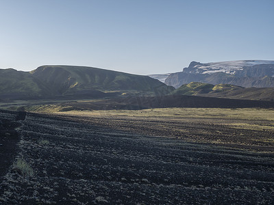 从Laugavegur远足小径欣赏冰岛Myrdalsjokull冰川的日出景色，火山景观中的绿色山谷与清晨的粉红光