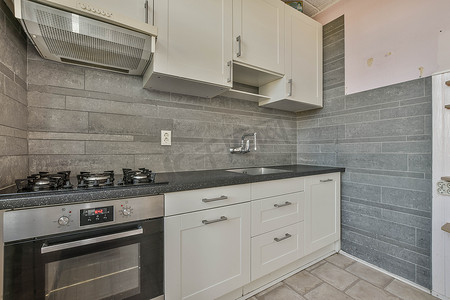 厨房配有白色橱柜、炉灶和水槽