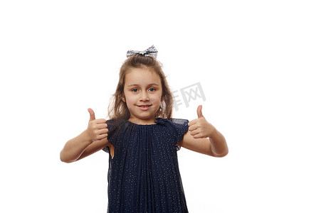 快乐的小女孩竖起大拇指看着相机，白色背景中突显，有广告文字的复制空间