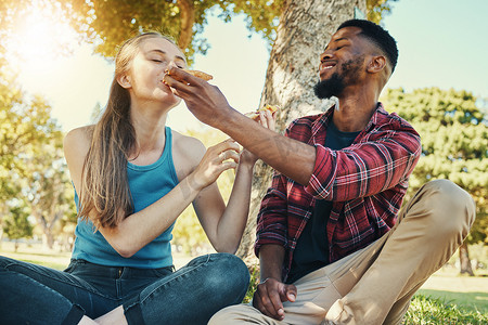约会夏天摄影照片_夏季，与一对多元化情侣在公园里吃披萨、吃美食和野餐，一起度过浪漫的约会。