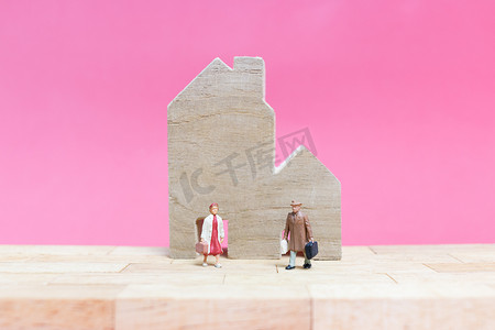 夫妇与粉红色背景的房子，