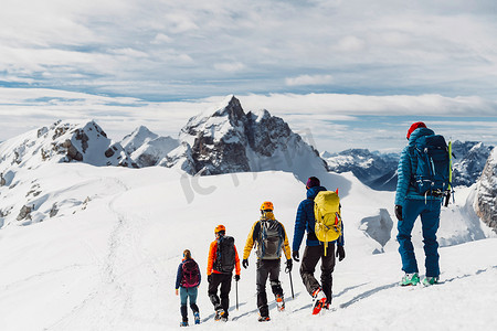 从后面看，五位登山者排着队从雪山下山