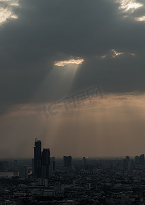 阳光穿过云层，照亮曼谷的摩天大楼