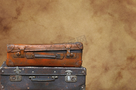 棕色纸上的旧复古旅行箱