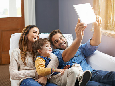 自拍、平板电脑和幸福的家庭在家里一起放松，在互联网或网上发布社交媒体内容。