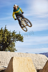 运动、山地自行车和跳跃在天空中与男子骑自行车进行自然锻炼、锻炼和比赛训练。